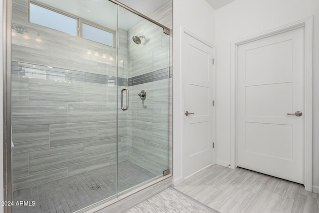 bathroom featuring a shower with door