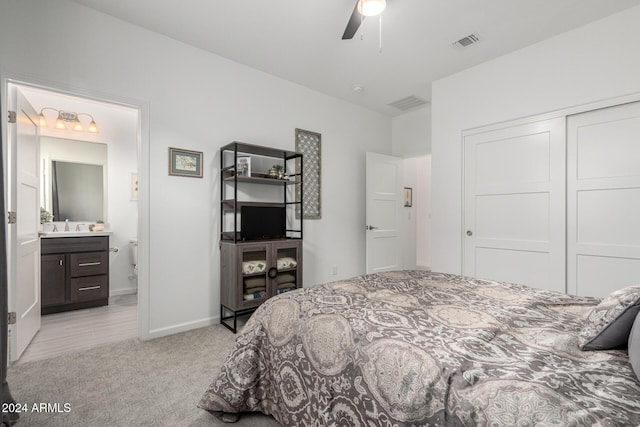 carpeted bedroom with ceiling fan, ensuite bathroom, and a closet