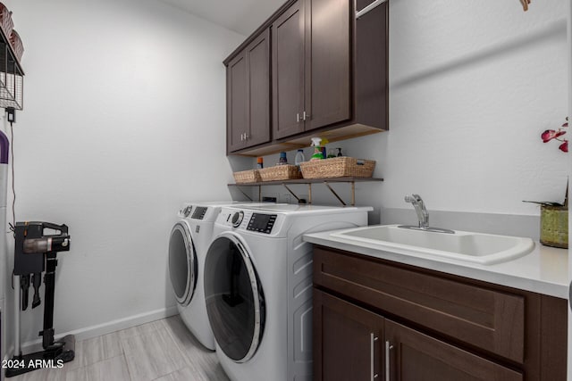 laundry area featuring separate washer and dryer, sink, and cabinets