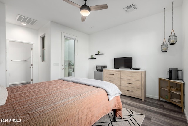 bedroom with ceiling fan, dark hardwood / wood-style floors, and connected bathroom