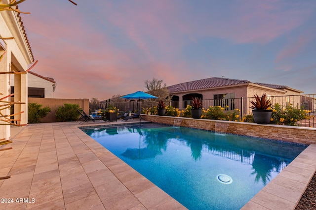 pool at dusk with a patio