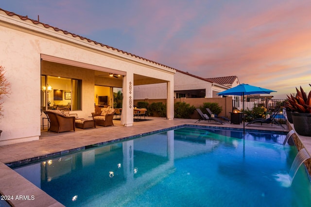 view of pool featuring pool water feature, an outdoor living space, and a patio