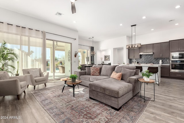 living room with ceiling fan and light hardwood / wood-style floors