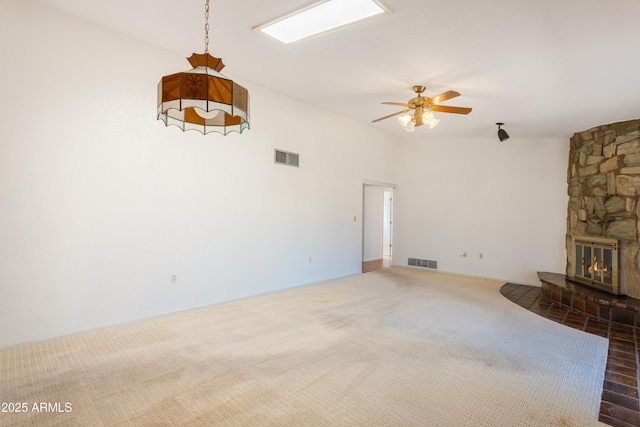 2232 Carmelita Dr, Sierra Vista, AZ 85635 - unfurnished living room with carpet, visible vents, a stone fireplace, and a ceiling fan