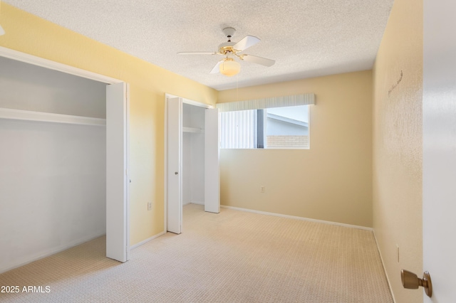 2232 Carmelita Dr, Sierra Vista, AZ 85635 - unfurnished bedroom featuring multiple closets, a ceiling fan, carpet flooring, and a textured ceiling