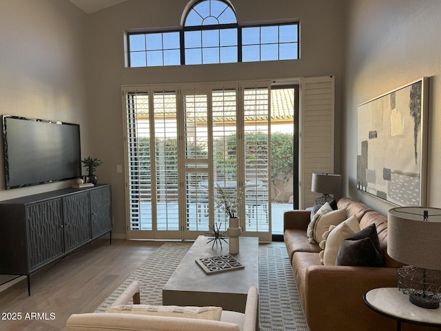 living room with high vaulted ceiling and wood finished floors