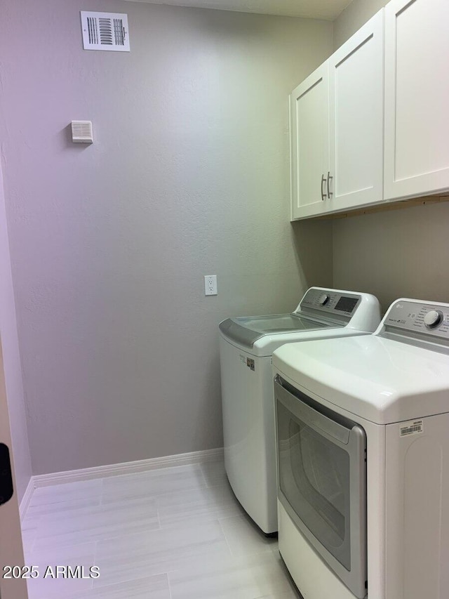 washroom with washer and dryer, visible vents, cabinet space, and baseboards