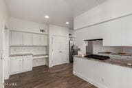 kitchen featuring dark wood-style floors, recessed lighting, freestanding refrigerator, and white cabinets