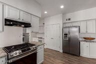 kitchen featuring appliances with stainless steel finishes, recessed lighting, wood finished floors, and extractor fan