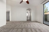 unfurnished living room with a ceiling fan and carpet flooring