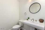 bathroom featuring a sink, toilet, and baseboards