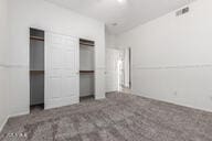 unfurnished bedroom with two closets and visible vents