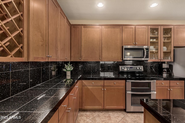 5840 E Holmes Ave, Mesa, AZ 85206 - kitchen featuring appliances with stainless steel finishes, decorative backsplash, tile counters, glass insert cabinets, and brown cabinetry