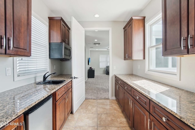 kitchen with stainless steel microwave, baseboards, light stone countertops, recessed lighting, and a sink