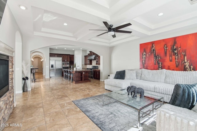 living area featuring recessed lighting, arched walkways, and coffered ceiling