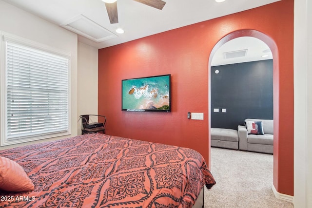 carpeted bedroom featuring visible vents, attic access, recessed lighting, arched walkways, and ceiling fan