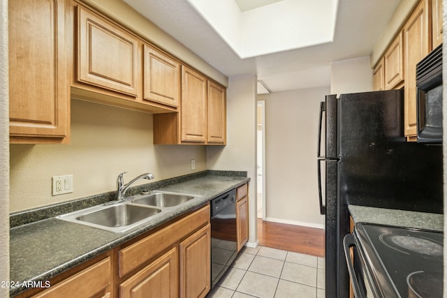 kitchen with light tile patterned flooring, black appliances, and sink