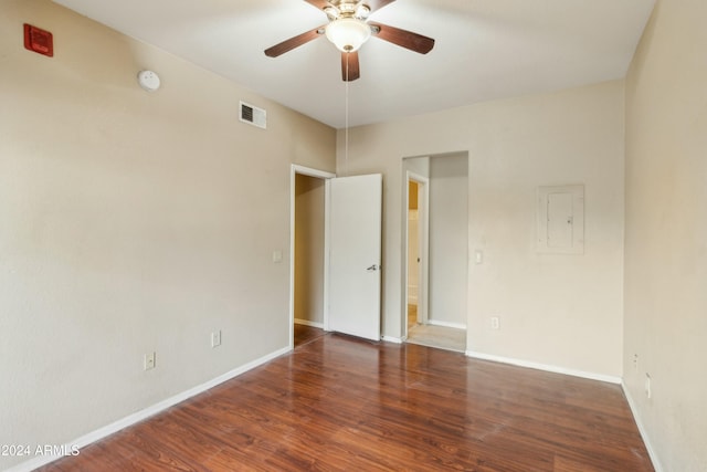 unfurnished room with electric panel, ceiling fan, and dark wood-type flooring