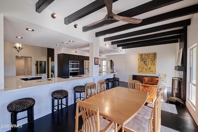 dining area with dark hardwood / wood-style flooring, beam ceiling, and ceiling fan