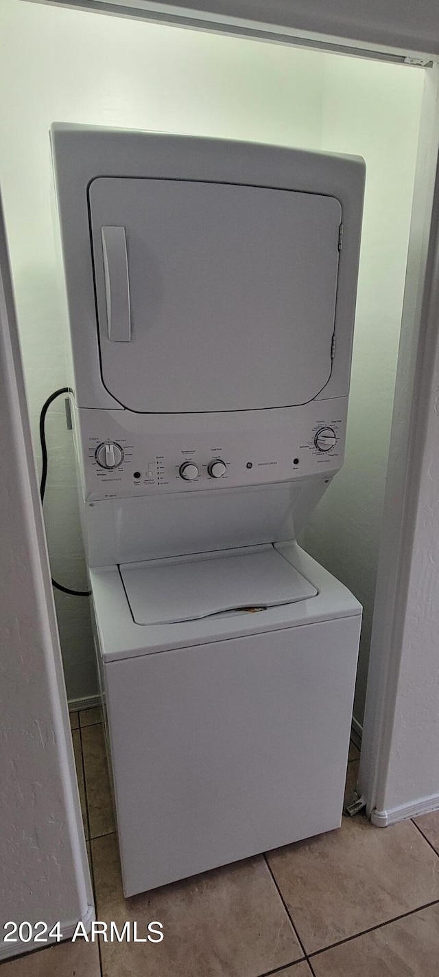16021 N 30th St Unit 113, Phoenix, AZ 85032 - washroom with stacked washer / dryer and light tile patterned floors