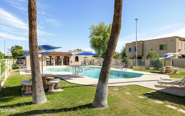 community pool with a lawn, a patio, and fence