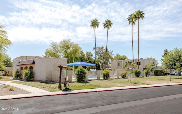 view of front facade with fence and stucco siding