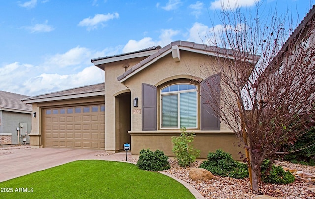 view of front of property featuring a front lawn, driveway, an attached garage, and stucco siding