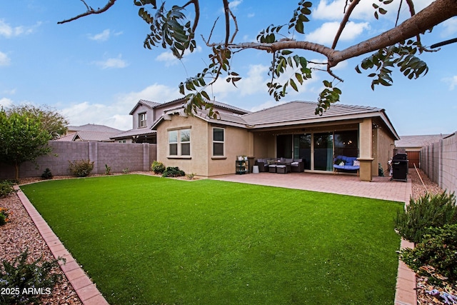 rear view of property featuring a tile roof, a patio, stucco siding, a lawn, and a fenced backyard