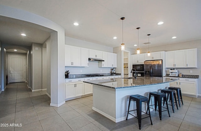 kitchen with an island with sink, black appliances, and white cabinets