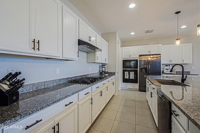 kitchen with white cabinetry, a sink, dark stone countertops, under cabinet range hood, and black appliances