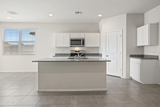 1343 W Hess Ave, Coolidge, AZ 85128 - kitchen with stainless steel microwave, a sink, dark stone countertops, and visible vents
