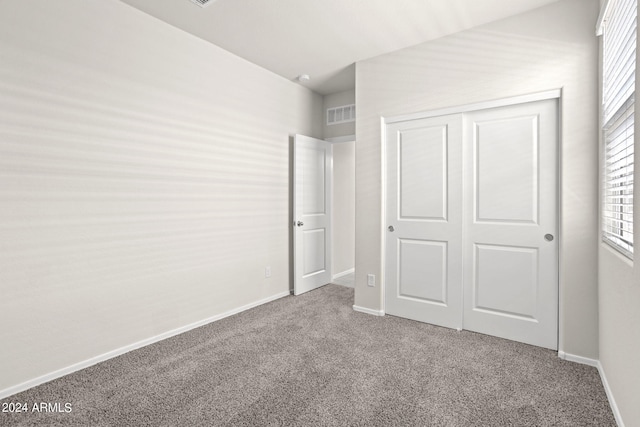 1343 W Hess Ave, Coolidge, AZ 85128 - unfurnished bedroom featuring baseboards, visible vents, a closet, and carpet