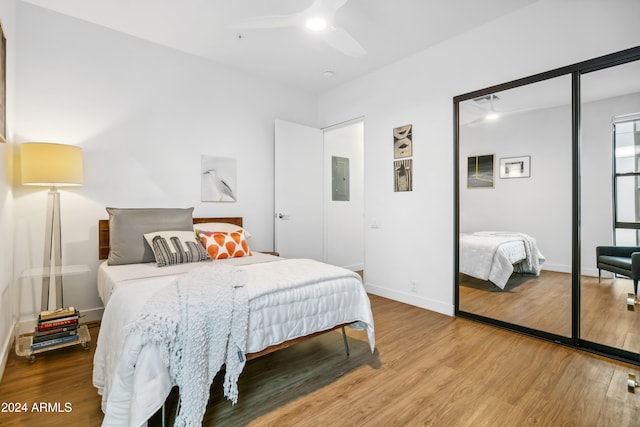 bedroom featuring electric panel, a closet, hardwood / wood-style flooring, and ceiling fan