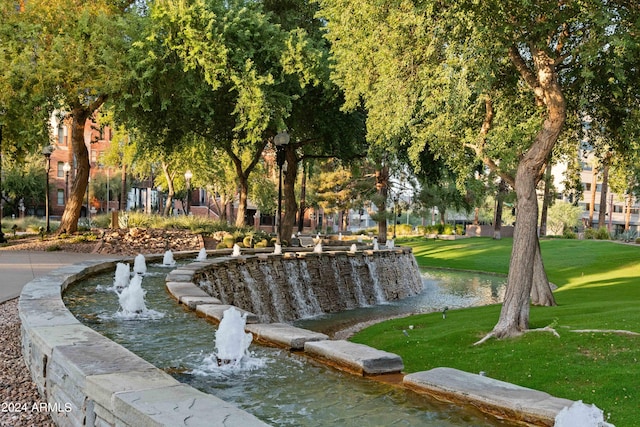 view of community with a yard and a water view