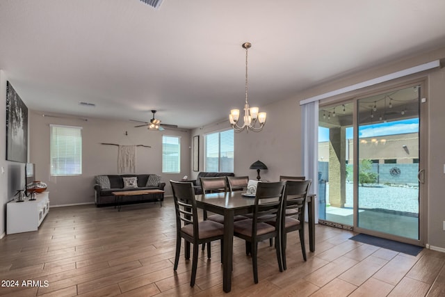 dining room with ceiling fan with notable chandelier and hardwood / wood-style floors