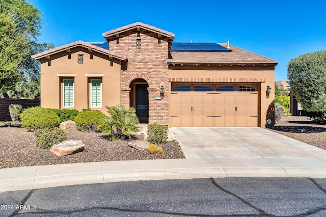 view of front facade with a garage and solar panels