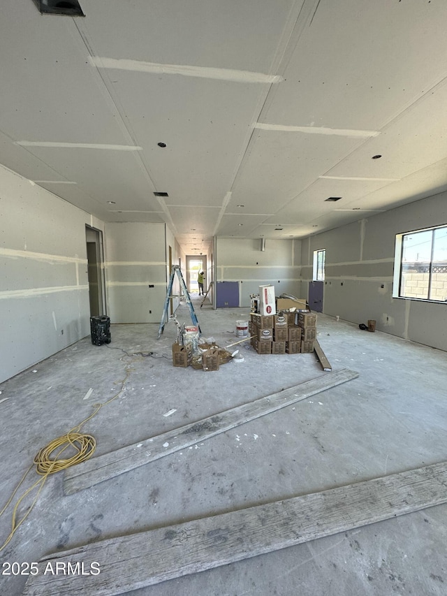 misc room with unfinished concrete flooring and healthy amount of natural light