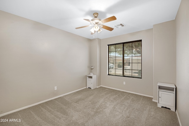 carpeted spare room with ceiling fan