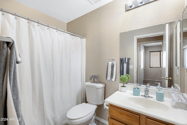 bathroom featuring a shower with curtain, vanity, and toilet