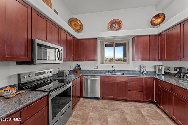 kitchen featuring sink, dark stone countertops, and stainless steel appliances