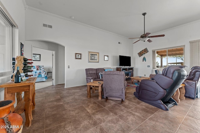 living room with crown molding, a towering ceiling, and ceiling fan