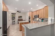 14687 W Amelia Ave, Goodyear, AZ 85395 - kitchen featuring a peninsula, recessed lighting, light countertops, and stainless steel microwave
