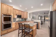 14687 W Amelia Ave, Goodyear, AZ 85395 - kitchen featuring appliances with stainless steel finishes, recessed lighting, a center island, a breakfast bar area, and a peninsula