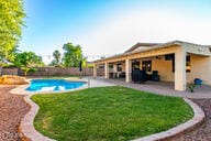 14687 W Amelia Ave, Goodyear, AZ 85395 - view of swimming pool featuring a patio and a lawn
