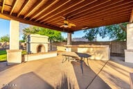 14687 W Amelia Ave, Goodyear, AZ 85395 - view of patio with a fireplace with raised hearth, a ceiling fan, and outdoor dining space