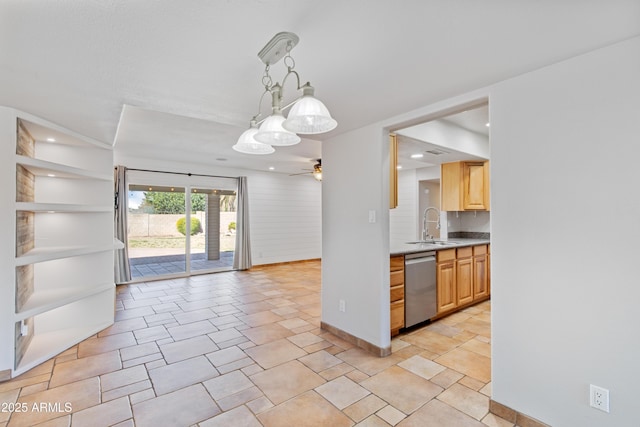 kitchen with open floor plan, light countertops, stainless steel dishwasher, a ceiling fan, and a sink