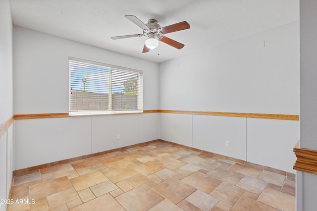 empty room featuring baseboards and ceiling fan