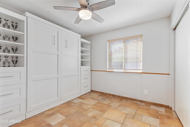 unfurnished bedroom featuring stone finish floor, a ceiling fan, and a closet