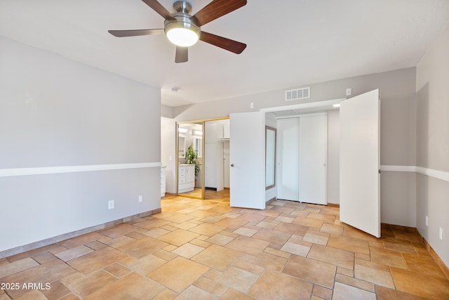 spare room featuring visible vents, stone finish floor, and ceiling fan