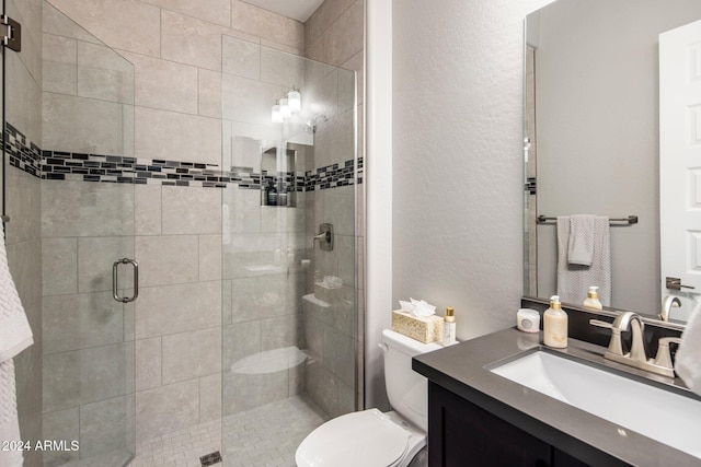 bathroom with vanity, a shower with shower door, and toilet